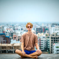 Contrary to some common myths about meditation, you don’t have to sit cross-legged—like this young man is doing—to meditate.
