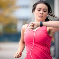 This woman is jogging while using wearable technology for health tracking.
