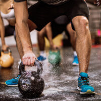 Athletes who take part in activities that involve explosive movements, like these people working out with kettlebells, might need a higher daily carb intake than others.